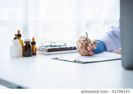 Close-up of doctor's hands writing prescription with bottle with pills. Healthcare, medical and pharmacy concept. Close-up of doctor's hands writing prescription with bottle with pills. Healthcare, medical and pharmacy concept. 91708143