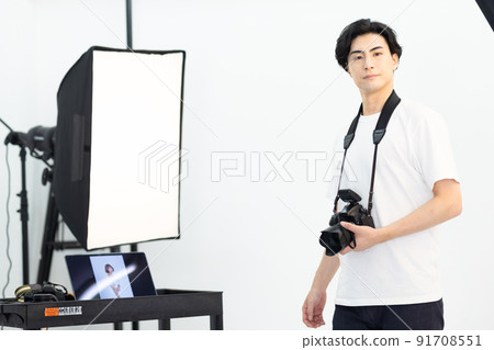 Photographer with a camera in the shooting studio 91708551