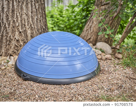 Balance training half ball in a backyard Balance training half ball in a backyard 91708578