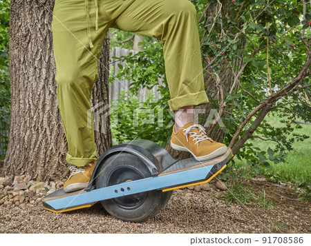 one-wheeled electric skateboard in a backyard 91708586