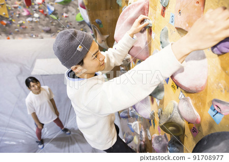 一個女人看著一個年輕人抱石 一個女人看著一個年輕人抱石 91708977