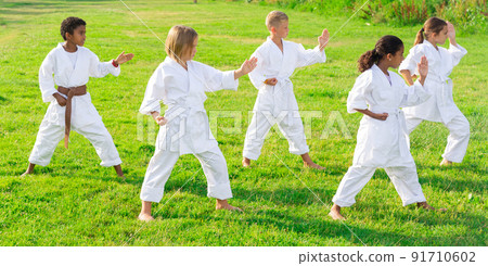 Group of kids in white kimono training Group of kids in white kimono training 91710602
