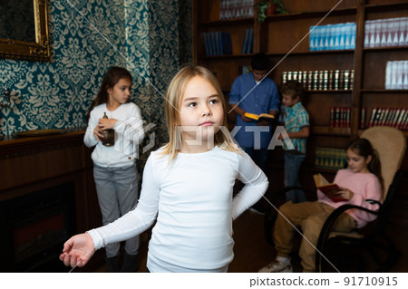 Thoughtful preteen girl solving puzzle in escape room 91710915