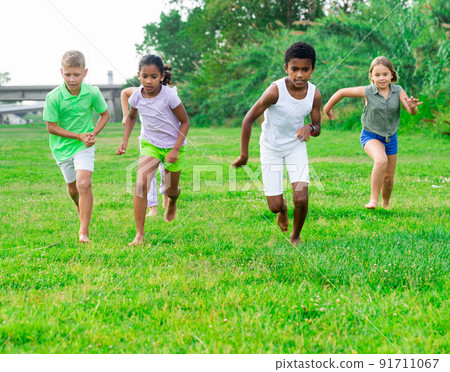Positive kids playing active games in park chasing each other 91711067