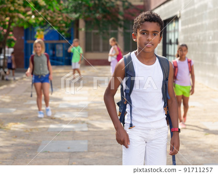 African american preteen boy with backpack walking outdoors African american preteen boy with backpack walking outdoors 91711257