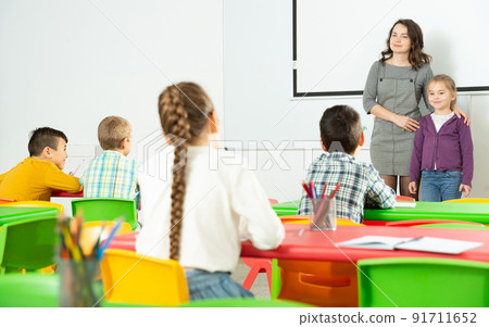 Teacher introducing new girl to class 91711652