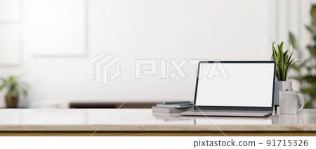 Laptop mockup and copy space on tabletop over blurred white living room in the background 91715326