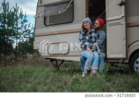 Romantic couple spending time together near trailer home. 91716085