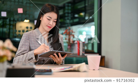 Elegant young-adult Asian businesswoman remote working in the coffee shop 91716302