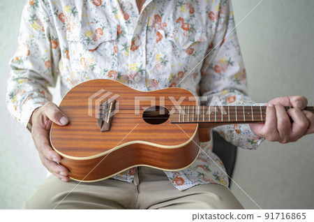Senior man enjoying ukulele 91716865