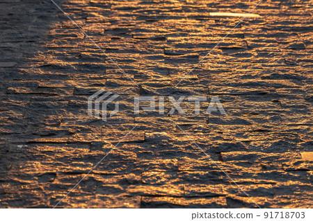 Stone block pavement in the rays of the setting sun. Texture 91718703