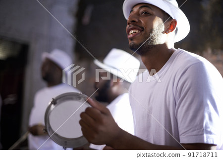 Bringing Brazil to life with their beats. Shot of a band playing their percussion instruments in a Brazilian setting. 91718711