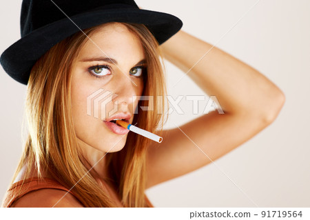 Bad girl. A young trendy woman smoking a cigarette. 91719564
