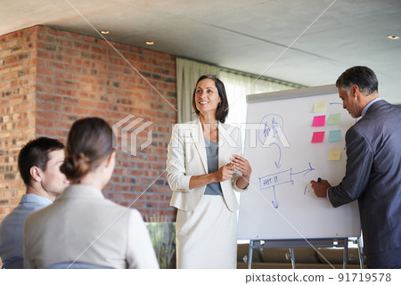 Plans to progress. Shot of two businesspeople giving a presentation to their colleagues. Plans to progress. Shot of two businesspeople giving a presentation to their colleagues. 91719578