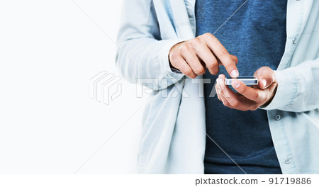Playing with my new phone. A cropped image of a casual male typing on his cellphone. 91719886
