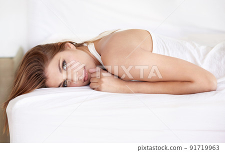 Being herself makes her beautiful. A gorgeous young woman lying on her bed in a sleepshirt. 91719963