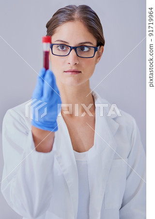 She holds the key to the cure. Shot of a scientist examining a medical sample while standing in a laboratory. 91719964