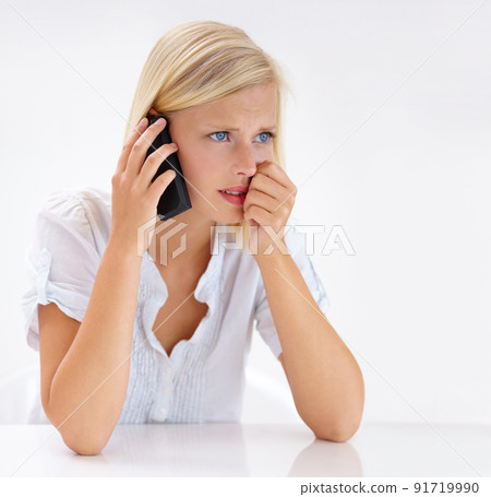 This cant be true. Shot of an attractive woman looking worried while talking on her cellphone. 91719990
