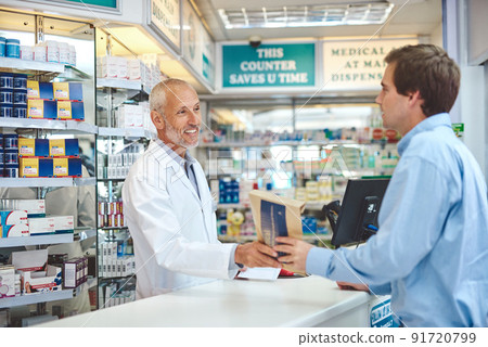 I hope you feel better. Cropped shot of a handsome mature male pharmacist helping a customer in the pharmacy. I hope you feel better. Cropped shot of a handsome mature male pharmacist helping a customer in the pharmacy. 91720799