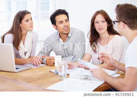 Dynamic business ideas. Shot of a group of young design professionals sitting at a table and having a brainstorming session. 91720921