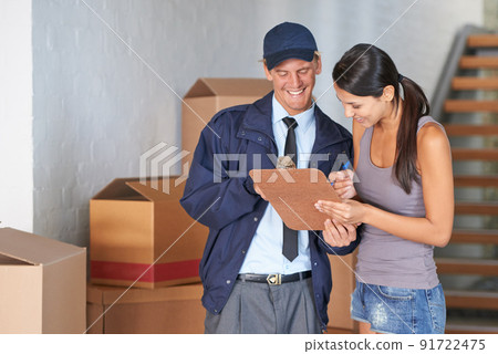 Finally her move was complete. Cropped shot of a beautiful woman receiving a delivery. Finally her move was complete. Cropped shot of a beautiful woman receiving a delivery. 91722475