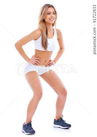 Start every day in a healthy way . Shot of an attractive and sporty young woman doing squats against a white background. 91722633