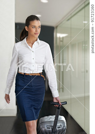 Shes an experienced corporate traveller. Cropped view of a young businesswoman pulling a suitcase behind her. 91723160