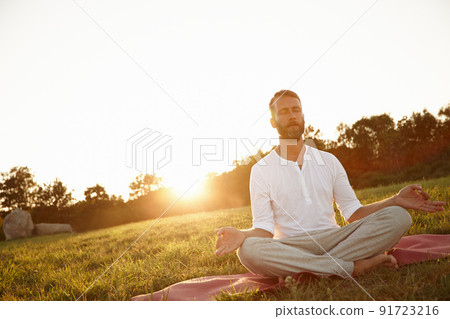 Transcendance at sunset. Shot of a handsome mature man meditating in the outdoors at sunset. Transcendance at sunset. Shot of a handsome mature man meditating in the outdoors at sunset. 91723216