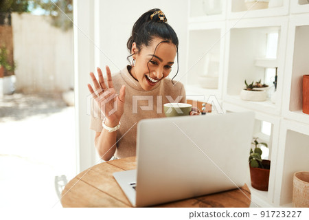 Greeting my followers in my new vlog. Cropped shot of an attractive young businesswoman sitting and vlogging on her laptop while enjoying a cup of coffee. 91723227