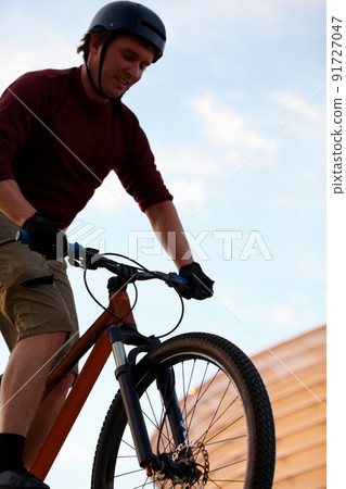 Practice, practice, practice. Low angle shot of a man doing tricks on his bike. 91727047