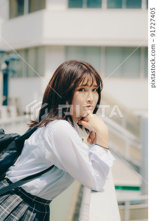 Schoolgirl in uniform and cityscape 91727405