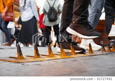 Close-up of yellow spikes for a tire puncture for stopping the car in a street of Istanbul 91727492