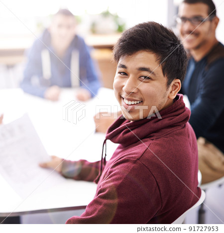 Meetings keep us on the same page. Portrait of a happy young man sitting in a meeting with his colleagues. 91727953