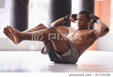 Hes a lean mean fighting machine. Shot of a middle-age boxer working out his abs in a gym. Hes a lean mean fighting machine. Shot of a middle-age boxer working out his abs in a gym. 91729106