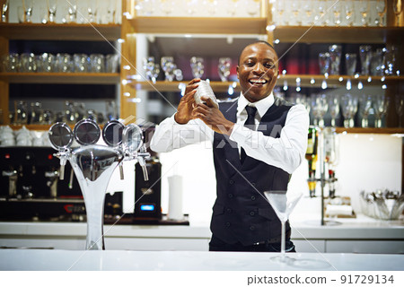 Its time to shake things up in here. Cropped shot of a well-dressed bartender standing behind the counter. 91729134