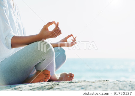 Absorbing natures peace. A young woman performing a yoga routine on the beach in the summer sun. Absorbing natures peace. A young woman performing a yoga routine on the beach in the summer sun. 91730127