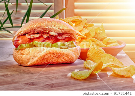 Hot dogs and potato chips on wooden board in sunny cafe Hot dogs and potato chips on wooden board in sunny cafe 91731441