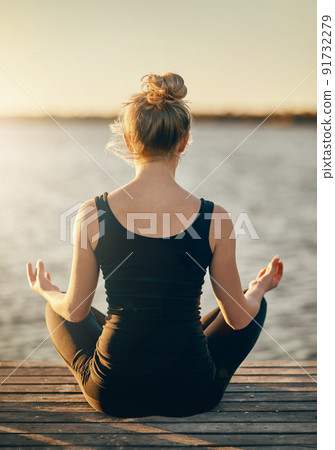 Mental fitness is just as important as physical. Rearview shot of a young woman meditating outdoors. Mental fitness is just as important as physical. Rearview shot of a young woman meditating outdoors. 91732279