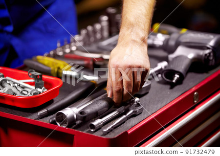 Finding the perfect tool. Cropped image of a mans hands grabbing a tool from his toolbox. 91732479