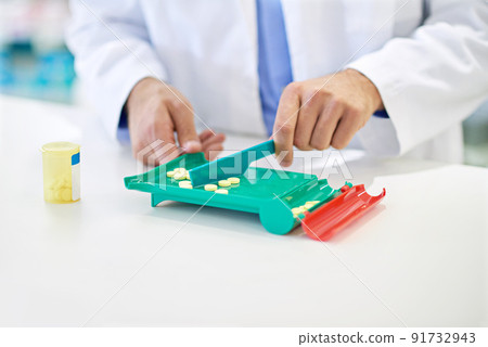Counting out the right amount for the prescription. A pharmacist counting pills. 91732943