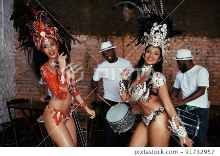 The thrill of performing live. Portrait of two beautiful samba dancers and their band. 91732957