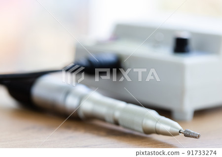 Manicure machine closeup. Metallic fraser on the desk. Selective focus. Manicure machine closeup. Metallic fraser on the desk. Selective focus. 91733274