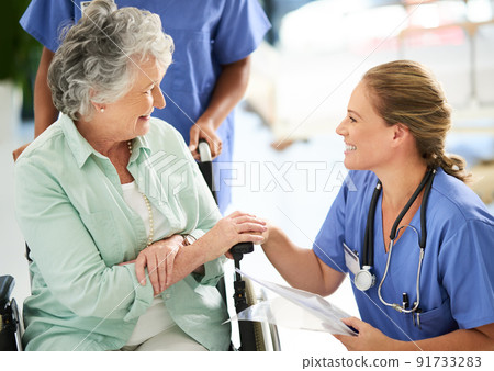 Cropped shot of an attractive female nurse discussing treatments with her wheelchair-bound senior patient in the hospital Cropped shot of an attractive female nurse discussing treatments with her wheelchair-bound senior patient in the hospital 91733283