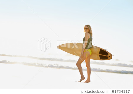 Enjoying the sunshine. A young surfer girl on the beach during the summer time. Enjoying the sunshine. A young surfer girl on the beach during the summer time. 91734117