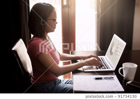 Working from home is more efficient for her. Cropped shot of an attractive young businesswoman working from home. Working from home is more efficient for her. Cropped shot of an attractive young businesswoman working from home. 91734130