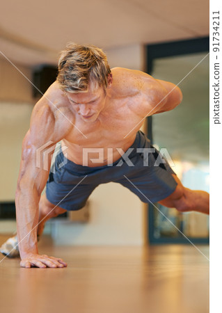 In excellent physical shape. Fit young man doing push ups in a health club. 91734211