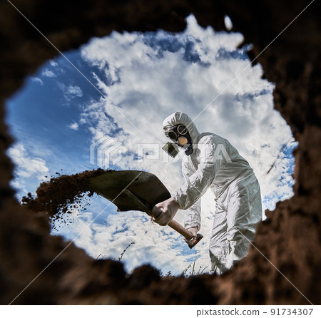 View from inside pit of unrecognizable male scientist in gas mask using shovel equipment for digging soil in hazard zone, analyzing nature environment, professional ecologist exploring pollution. View from inside pit of unrecognizable male scientist in gas mask using shovel equipment for digging soil in hazard zone, analyzing nature environment, professional ecologist exploring pollution. 91734307