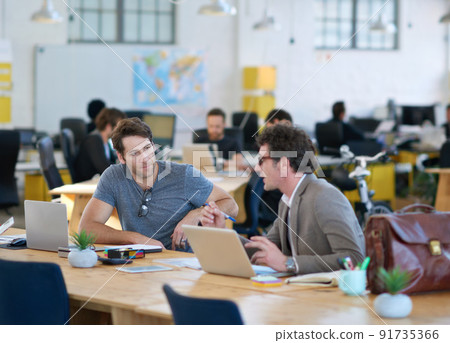 We make technology work for us. Shot of business colleagues discussing matters with the help of wireless technology in their office. We make technology work for us. Shot of business colleagues discussing matters with the help of wireless technology in their office. 91735366