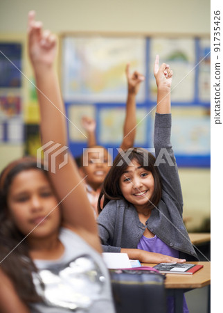 They all know the answer. A group of students raising their hands in class. They all know the answer. A group of students raising their hands in class. 91735426