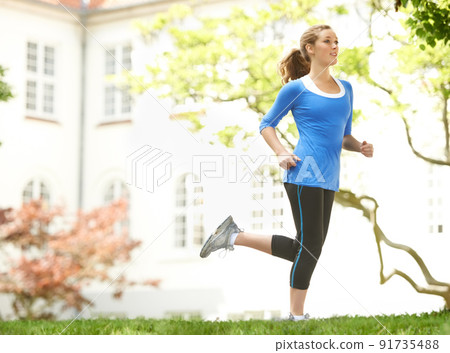 Getting fit. Attractive young woman out for a run. 91735488